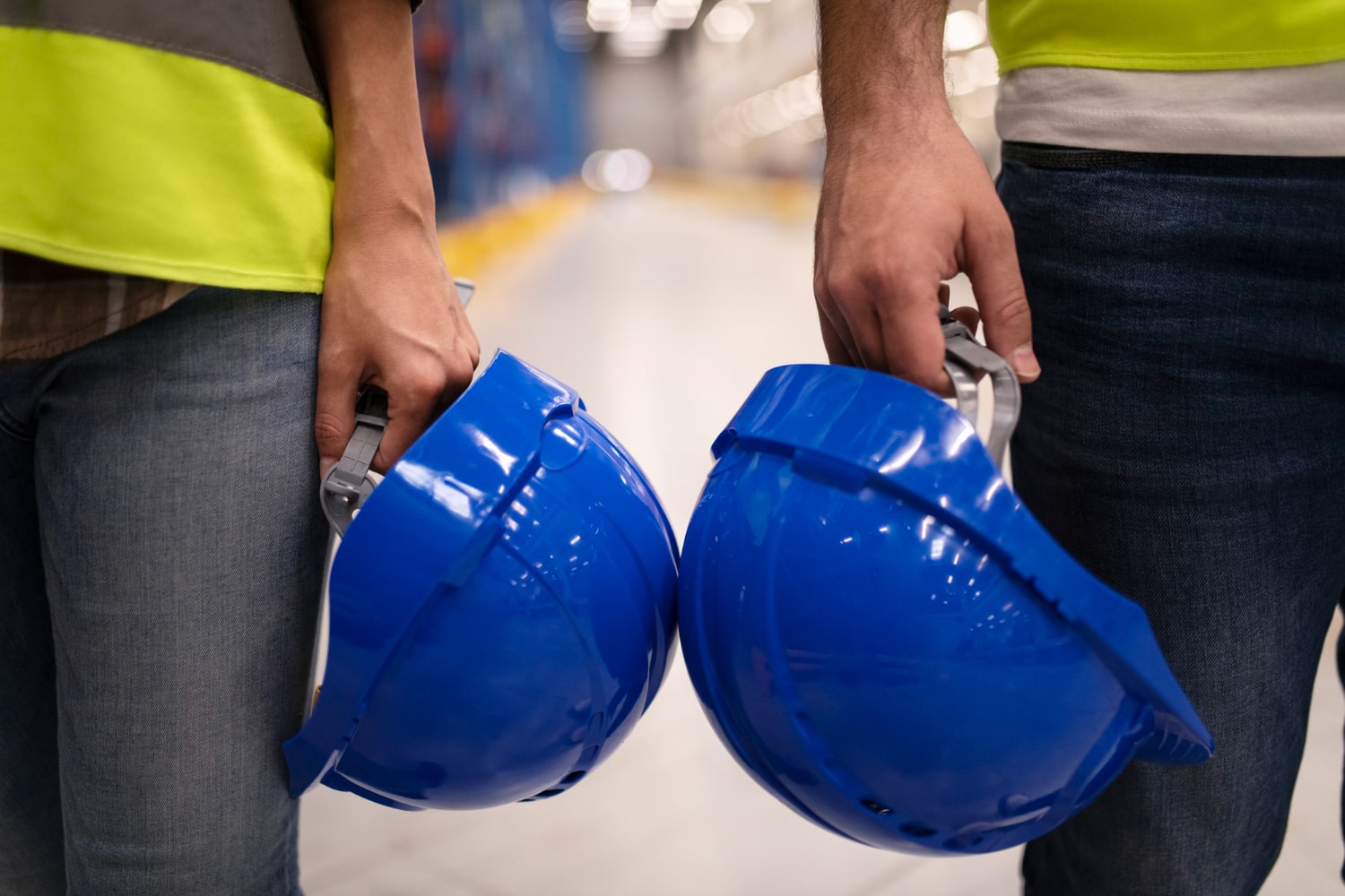 close-up-two-unrecognizable-industrial-workers-holding-hardhat-protection-helmets-min